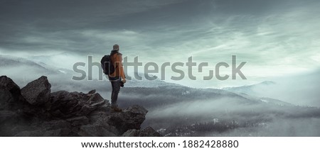 photographer hiker in foggy landscape