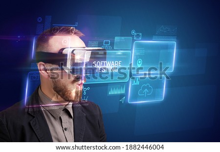 Businessman looking through Virtual Reality glasses with SOFTWARE TESTING inscription, new technology concept