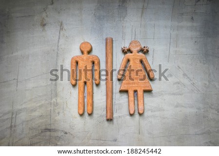 Restroom sign made of teak wood on concrete wall
