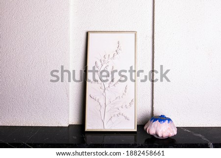 Stylish living room interior with botanical bas-relief wildflowers for wall art and white blue pumpkins. 3D Flower plaster and halloween decor. Modern and luxury interior of room. 