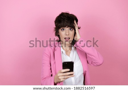 Young business woman over isolated pink background chatting on the phone with a worried expression