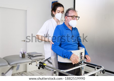 Physiotherapist assisting a patient with Amyotrophic Lateral Sclerosis. High quality photo Royalty-Free Stock Photo #1882519990