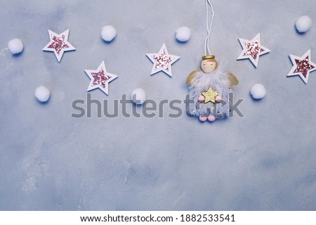 New Year or Christmas background. wooden gray background with winter angels, stars and small snowflakes. With place for your text, top view, copy space
