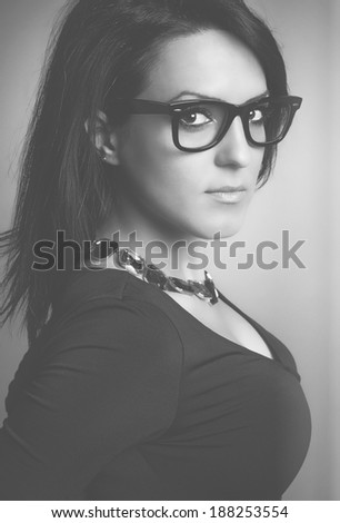Portrait of business lady with glasses, casual dress, jewelry and accessories. Black & White.