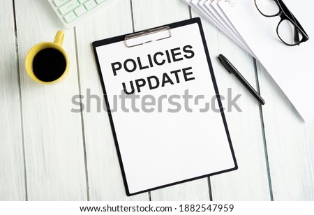 White notepad and human hand on the wooden background