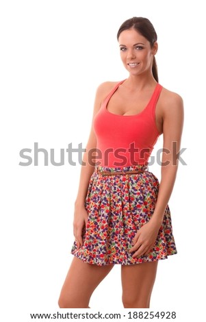 Summer photo of pretty young woman in mini skirt and top, smiling, looking at camera.