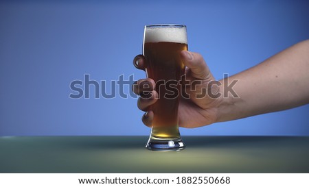 a man's hand holding a glass of craft beer.Copy space for designers. Drink 
concept