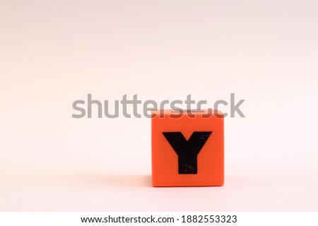 The letter Y inside a orange cube. Free space for extra text. Close up and isolated on a white background. 