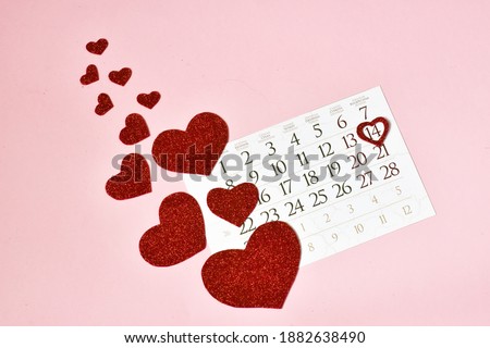 Calendar and hearts on a pink background. Happy Valentine's day. Congratulatory background by St. Valentine's Day. 
