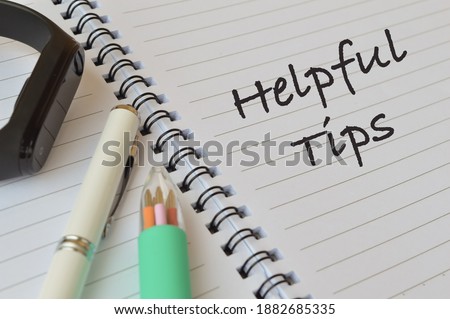 Selective focus of pens, watch and notebook written with text HELPFUL TIPS. Business and Education concept