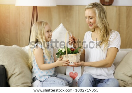 Happy mother day. Child daughter congratulates mom and gives her basket of spring flowers. Family concept
