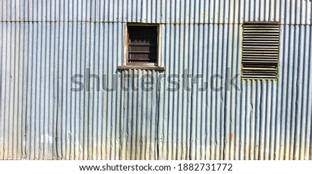 silver zinc corrugated iron rustic exterior wall with two windows