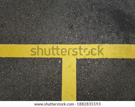 Yellow parking line on tar pavement surface. 