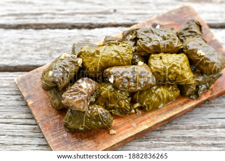 Dolmades - stuffed grape leaves  with rice the Greek way on wooden table .Stuffed greek wine leaves
