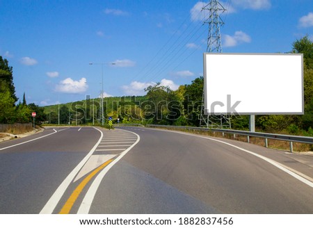 Empty white horizontal billboard on the roadside. Empty asphalt road, blank outdoor billboar mock up.
