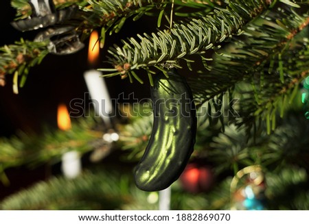 Decorated Christmas Tree With Hidden Glass Cucumber Decoration As Lucky Symbol And White Wax Candles. Festive Green Background. Royalty-Free Stock Photo #1882869070