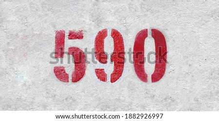 Red Number 590 on the white wall. Spray paint.