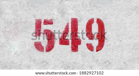 Red Number 549 on the white wall. Spray paint.