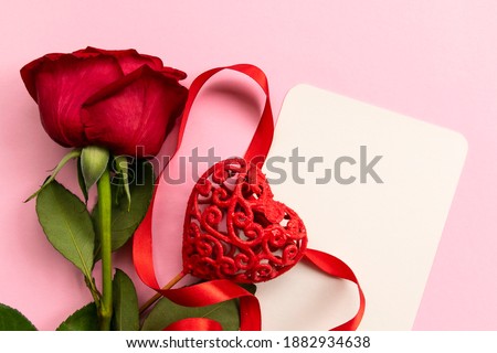 Red rose with decorated heart on pink background. Concept of Valentine's day, mother's day, women's day and birthday. Greetings card. Copy space and Flat lay.
