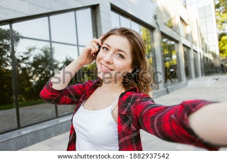 Selfie portrait of lovely woman listen music in headphones outdoors