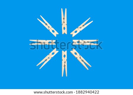 Star of  wooden clothespins isolated on blue background. A clothespin, or clothes peg is a fastener used to hang up clothes for drying, usually on a clothes line.