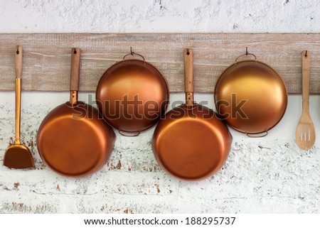 Copper  kitchen utensil on the white painted brick wall Royalty-Free Stock Photo #188295737