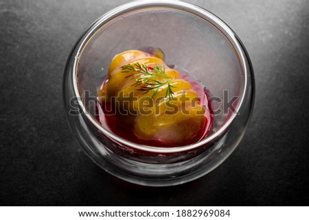 delicious piece of ice cream filled with sweet syrup in deep transparent plate. Fusion cuisine