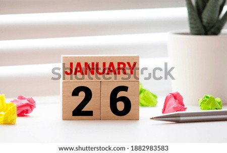 White block calendar present date 26 and month January on wood background.