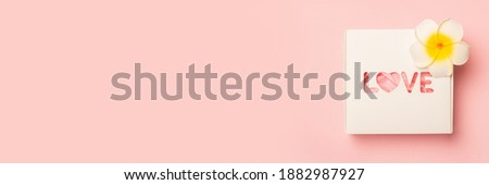 Gift box and flowers on a pastel pink background. Composition Valentine's Day. Flat lay, top view. Banner
