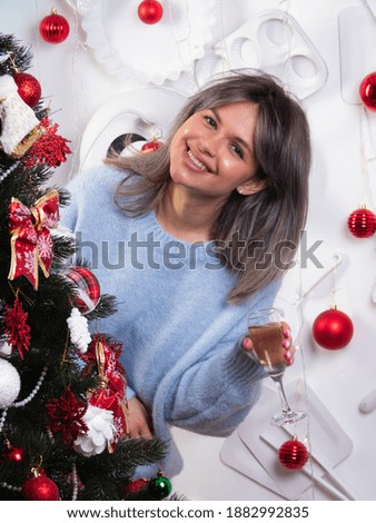 beautiful girl with a glass of champagne meets the new year and Christmas at the Christmas tree