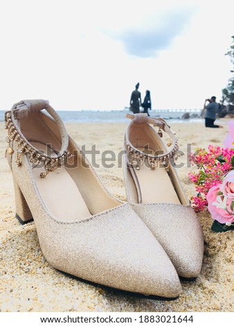 An image of high heels on the sand beach. Its can be used by a bride on their reception because of the classy and elegance design
