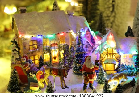 Miniature of winter scene with Christmas houses, people, trees, Santa Claus on deers Christmas concept. High quality photo