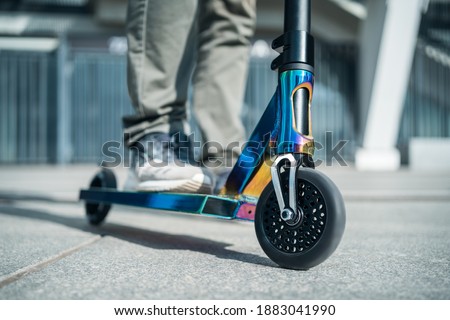 young teenager in sneaker on modern extreme stunt kick scooter in skatepark Royalty-Free Stock Photo #1883041990