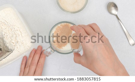 Dissolving dry yeast in warm milk. Step by step flat bread recipe, baking process. Close up view from above, woman hands