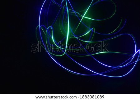 beautiful abstract theme of multi colored green blue spectrum light painting evil dark night streaks ray blowing art glowing energy neon