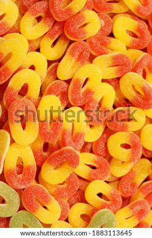 Colorful texture using as background. A lot of sweets. Background 3d rendering illustration. Orange and black multiple jelly candies in powdered sugar. Confectionery wallpaper concept. Copy space