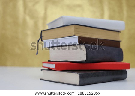 Books on the table with gold background