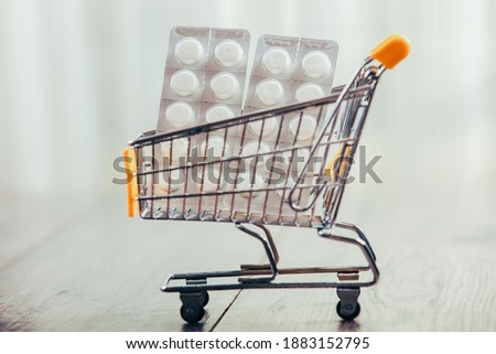 Shopping trolley on wooden table, tablets and credit card in trolley