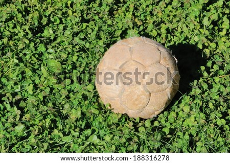Old and faded soccer ball in the grass