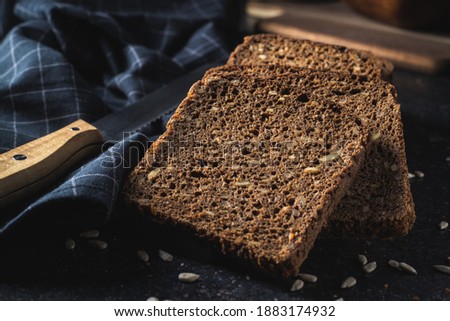 Dieting cereal bread with sunflower seeds on black table.