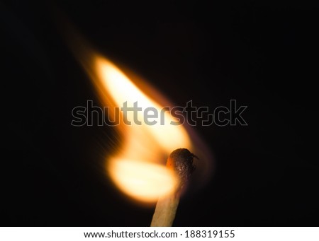 Close up burning matchstick on black background