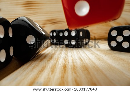 Red and black dice cubes on wooden background