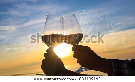 Selective focus of couple hands which  Couple drinking wine on the rooftop bar restaurant and the city background