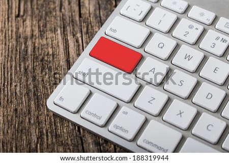 Blank empty red button on the keyboard close-up on wooden background