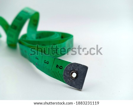 green plastic flexible ruler. this tool is used to measure height and width, chest and abdominal circumference, and to measure the length of other objects Royalty-Free Stock Photo #1883231119