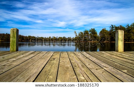 A Day At The Lake. Wooden dock overlooking a gorgeous lake in the wilderness.  Ludington State Park. Ludington, Michigan.   Royalty-Free Stock Photo #188325170