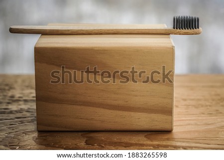 organic bamboo tooth brush, personal, fresh, biodegradable, plastic free product. Advertising naturally trends, clinic recommends. Wooden base, black environmental bristles. Minimal concept picture 