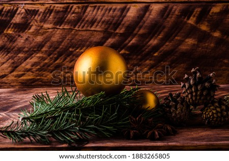 cones and branches on wooden boards with a large Christmas ball