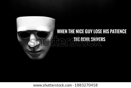 A low key and selective focus picture of toy face mask on with the word when the nice guys lose his patience the devil shivers on dark background.