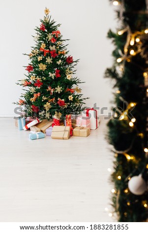 decorated Christmas tree with New Year's gifts in a room with a window